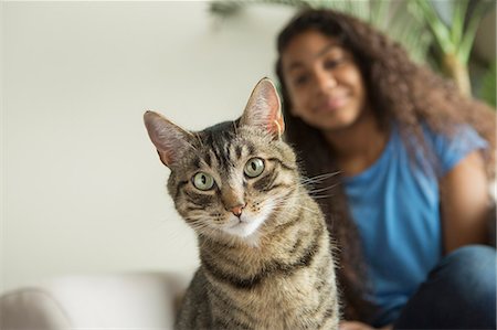 simsearch:6118-08725493,k - A girl sitting on a sofa with a pet cat. Stock Photo - Premium Royalty-Free, Code: 6118-08883049