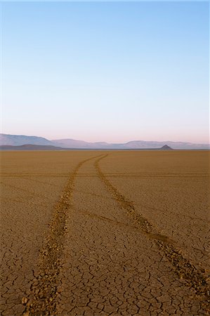 simsearch:6118-08883010,k - Tyre tracks in a desert landscape with mountains in the distance. Stock Photo - Premium Royalty-Free, Code: 6118-08883016