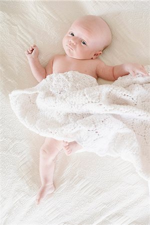 simsearch:6118-08827464,k - A baby boy lying on his back on a bed. Stockbilder - Premium RF Lizenzfrei, Bildnummer: 6118-08827477