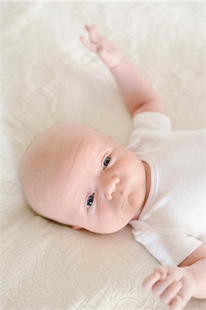 simsearch:6118-08827464,k - A baby boy lying on his back on a bed. Stockbilder - Premium RF Lizenzfrei, Bildnummer: 6118-08827476