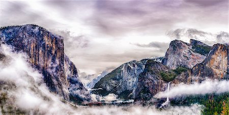 The Tunnel View, through a canyon in the Yosemite National park in winter, with mist rising from the valleys Fotografie stock - Premium Royalty-Free, Codice: 6118-08827494