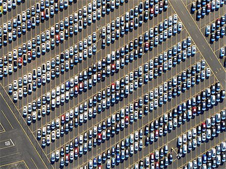 parcheggio - Aerial view of a car distribution centre, new cars parked in rows on a lot ready for sale. Fotografie stock - Premium Royalty-Free, Codice: 6118-08827526