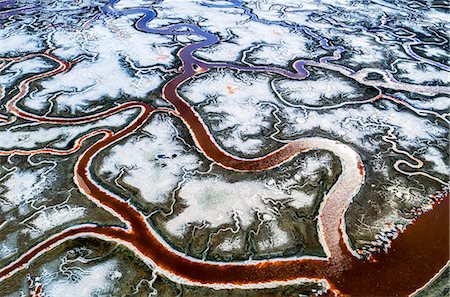 salt plains - Aerial view of the landscape, meandering water channels and the salt pans with white salt and mineral deposits at Alvisio. Photographie de stock - Premium Libres de Droits, Code: 6118-08827531