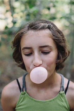 Eleven year old girl blowing bubble gum bubble Stock Photo - Premium Royalty-Free, Code: 6118-08827603