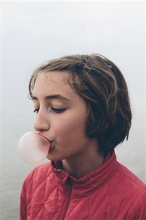 Eleven year old girl blowing bubble gum bubble Stock Photo - Premium Royalty-Free, Code: 6118-08827621
