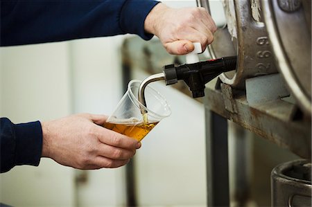 simsearch:649-08423118,k - Man drawing foaming amber liquid, beer from a metal keg in a brewery for testing. Fotografie stock - Premium Royalty-Free, Codice: 6118-08947463