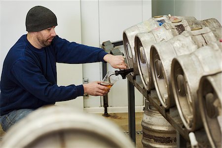 simsearch:649-08423118,k - Man drawing some beer from a metal keg in a brewery for testing. Fotografie stock - Premium Royalty-Free, Codice: 6118-08947464