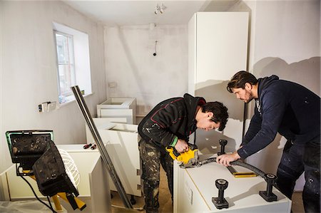 simsearch:614-01171023,k - Two builders, cutting plasterboard for a kitchen unit with a circular saw. Foto de stock - Sin royalties Premium, Código: 6118-08947491