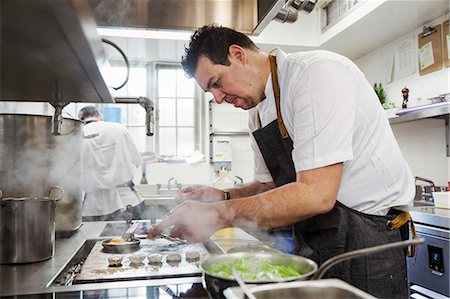 Chef cooking in the kitchen of a small boutique hotel. Stock Photo - Premium Royalty-Free, Code: 6118-08947543