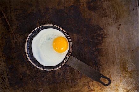 simsearch:6118-08947561,k - High angle view of a fried egg in a frying pan. Foto de stock - Royalty Free Premium, Número: 6118-08947542