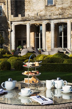 scone - A table in a garden outside an old house, with cake stand and a selection of cakes and sandwiches set for a traditional afternoon tea. Photographie de stock - Premium Libres de Droits, Code: 6118-08947553
