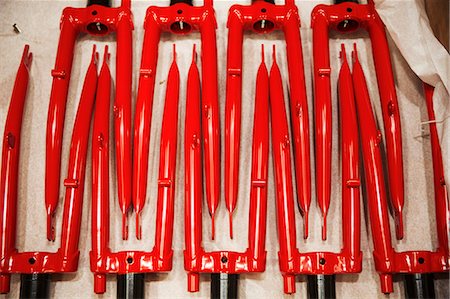 simsearch:649-06433371,k - Close up of red metal shapes, red bicycle forks laid out in a pattern. Photographie de stock - Premium Libres de Droits, Code: 6118-08947596