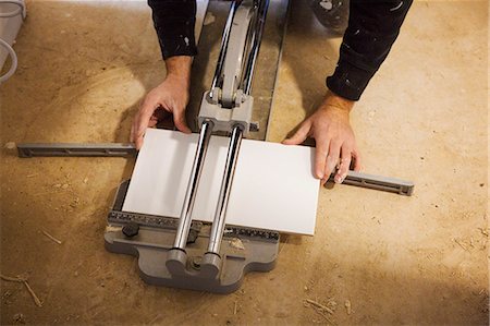 simsearch:614-01171023,k - A builder, tiler kneeling on the floor, cutting a tile. Foto de stock - Sin royalties Premium, Código: 6118-08947503