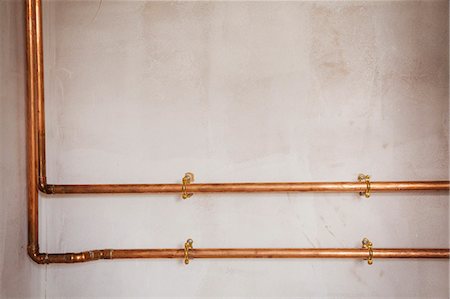 Copper pipes running along an interior wall. Photographie de stock - Premium Libres de Droits, Code: 6118-08947516