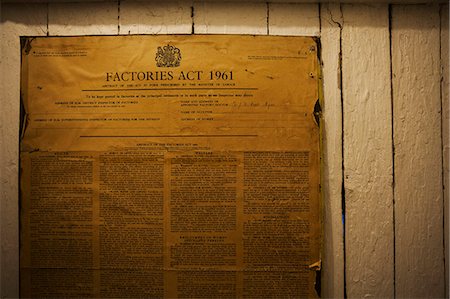 simsearch:6118-08947633,k - Yellowed poster of the Factories Act from 1961 on a wall in a shoemaker's workshop. Documentation. Photographie de stock - Premium Libres de Droits, Code: 6118-08947650