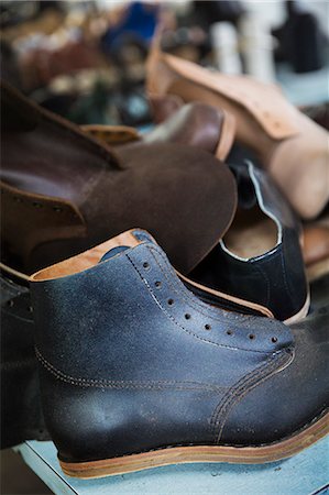 simsearch:6118-08947633,k - Close up of a black and brown leather shoes and work boots in a shoemaker's workshop. Photographie de stock - Premium Libres de Droits, Code: 6118-08947657