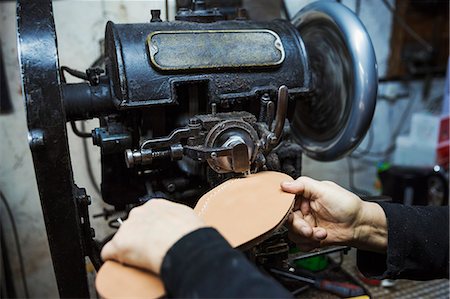 simsearch:6118-08947633,k - Close up of worker in a shoemaker's workshop, using a machine to sew a leather sole. Photographie de stock - Premium Libres de Droits, Code: 6118-08947680