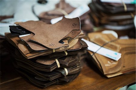 simsearch:6118-08947633,k - Close up of a stack of brown leather pieces in a shoemaker's workshop. Photographie de stock - Premium Libres de Droits, Code: 6118-08947636