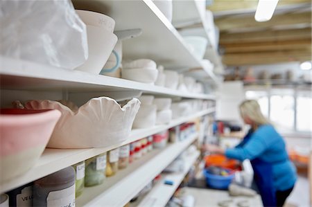 simsearch:6118-08660001,k - A woman working at a bench in a pottery studio. Shelves storing pots and bowls. Stock Photo - Premium Royalty-Free, Code: 6118-08947836