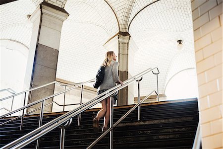 A woman walking up the steps of a subway, travelling in the city. Stock Photo - Premium Royalty-Free, Code: 6118-08971284