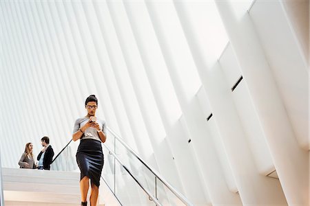 stairs and city - A woman walking down a staircase in the Oculus building, the World Trade Centre hub, modern architectural design with a ribbed vaulted roof space. Stock Photo - Premium Royalty-Free, Code: 6118-08971291