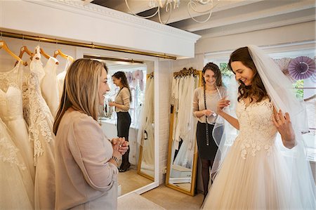 simsearch:6118-08971470,k - A bride trying on a dress, with the assistance of two women in a bridal boutique. Photographie de stock - Premium Libres de Droits, Code: 6118-08971440