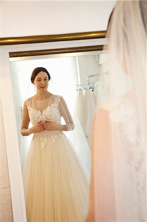 simsearch:6118-08971470,k - A woman in a wedding dress, standing in front of the mirror, in a bridal boutique. Photographie de stock - Premium Libres de Droits, Code: 6118-08971461