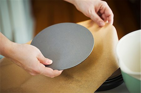 simsearch:6118-08971487,k - Close up high angle view of person holding round metal baking tin base over baking paper. Stockbilder - Premium RF Lizenzfrei, Bildnummer: 6118-08971473