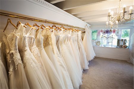 simsearch:6118-08971470,k - Rows of wedding dresses on display in a specialist wedding dress shop. Bridal Boutique. Photographie de stock - Premium Libres de Droits, Code: 6118-08971470