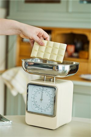 simsearch:6118-08971487,k - Close up of hand placing a bar of white chocolate onto an analogue kitchen scale. Stockbilder - Premium RF Lizenzfrei, Bildnummer: 6118-08971478