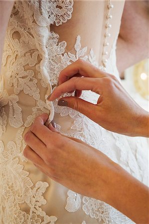 simsearch:6118-08971470,k - A dressmaker taking in a wedding dress, pinning and fitting it to the client. Photographie de stock - Premium Libres de Droits, Code: 6118-08971426