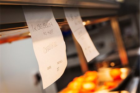 simsearch:6118-08947769,k - Close up of handwritten order tabs in a restaurant kitchen. Stock Photo - Premium Royalty-Free, Code: 6118-08971547