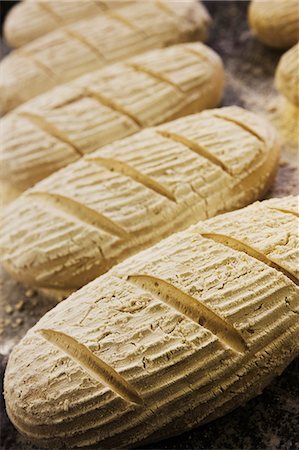 simsearch:6118-08971609,k - Close up high angle view of bread dough shaped into loaves, dusted with flour. Foto de stock - Royalty Free Premium, Número: 6118-08971570