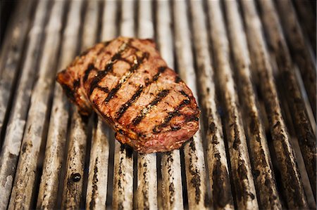 simsearch:6118-08971609,k - Close up high angle view of a steak on a griddle. Foto de stock - Royalty Free Premium, Número: 6118-08971589