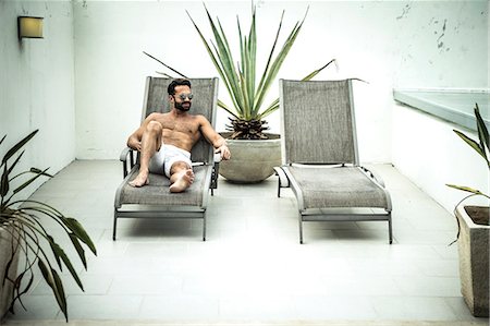 A man lying on a sun lounger. Foto de stock - Sin royalties Premium, Código: 6118-08991491