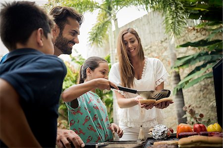 simsearch:6118-08991513,k - A couple standing at a barbecue cooking food. Foto de stock - Royalty Free Premium, Número: 6118-08991512