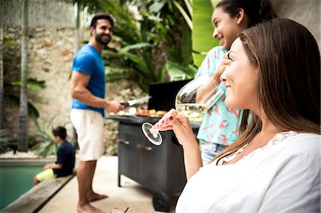 simsearch:6118-08991513,k - A family holding a barbecue by a swimming pool. Foto de stock - Royalty Free Premium, Número: 6118-08991520