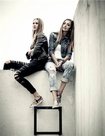 simsearch:6118-09039292,k - Two young women sitting on top of a concrete wall. Foto de stock - Sin royalties Premium, Código: 6118-08991532