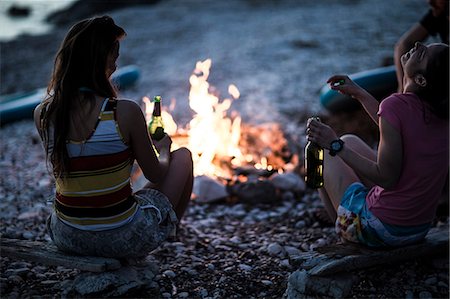 simsearch:6118-09027946,k - A group of young people gathered on a beach around a campfire.. Stock Photo - Premium Royalty-Free, Code: 6118-08991644