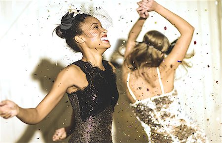 simsearch:6118-09039245,k - Two young women dancing with confetti falling. Foto de stock - Sin royalties Premium, Código: 6118-08991603