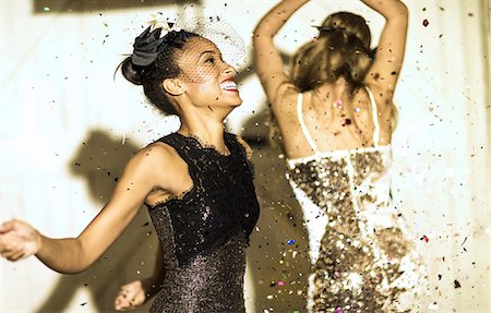 simsearch:6118-09039245,k - Two young women dancing with confetti falling. Foto de stock - Sin royalties Premium, Código: 6118-08991602