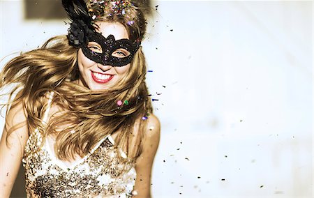 paillette - Young woman wearing a black face mask at a party with confetti falling. Photographie de stock - Premium Libres de Droits, Code: 6118-08991607