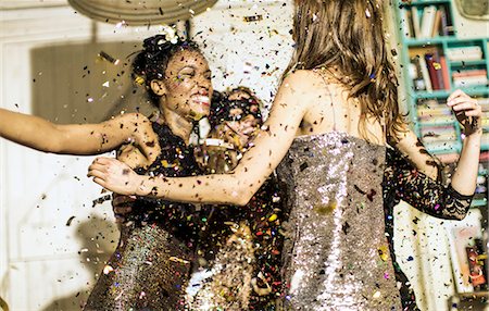 Group of young people celebrating at a party with falling confetti. Foto de stock - Sin royalties Premium, Código: 6118-08991610