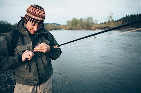 simsearch:6118-07440105,k - Middle aged man fly fishing on the Hoh River, Olympic National Park, Washington. Photographie de stock - Premium Libres de Droits, Code: 6118-08910371