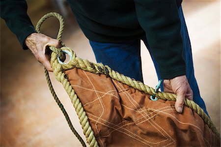 simsearch:6118-08947795,k - Close up of a man in a sailmaker's workshop holding a sail. Stock Photo - Premium Royalty-Free, Code: 6118-08928157