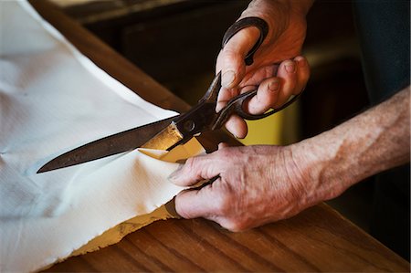 simsearch:693-05794500,k - Close up of a man in a sailmaker's workshop cutting a piece of sailcloth with a pair of scissors. Stockbilder - Premium RF Lizenzfrei, Bildnummer: 6118-08928162
