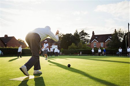 senior ball - A lawn bowls player standing on a small yellow mat preparing to deliver a bowl down the green, the smooth grass playing surface. Stock Photo - Premium Royalty-Free, Code: 6118-09059645