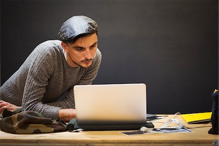 front photos for workshop note book - A man in a leather cap using a laptop computer. Stock Photo - Premium Royalty-Free, Code: 6118-09059717
