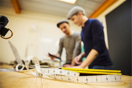 simsearch:6118-09059818,k - Two men at a workbench, using a digital tablet and laptop, a measuring tape in the foreground. Stock Photo - Premium Royalty-Free, Code: 6118-09059714