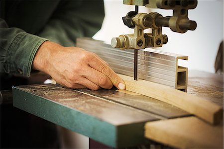 A craftsman using a machine drill on a piece of smooth planed shaped wood. Stock Photo - Premium Royalty-Free, Code: 6118-09059738